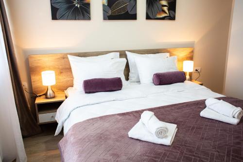a bedroom with a large bed with towels on it at Galaxy Apartments in Belgrade