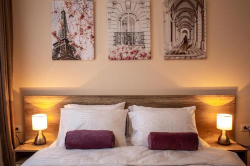 una camera con un letto con tre immagini appese al muro di Galaxy Apartments a Belgrado