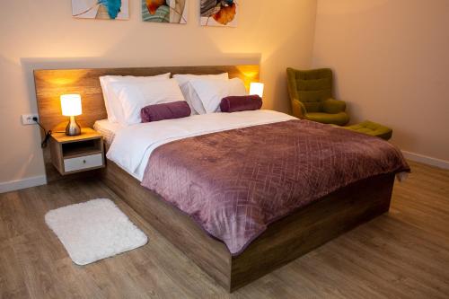 a bedroom with a large bed and a chair at Galaxy Apartments in Belgrade