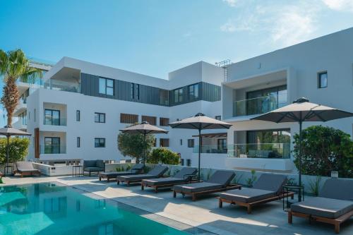 una imagen de un hotel con sillas y sombrillas junto a una piscina en Silver Park en Pafos