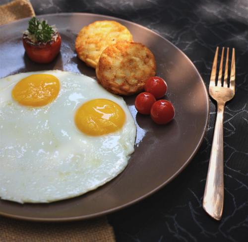 a plate of food with eggs and tomatoes and a fork at Courtyard by Marriott Hyderabad in Hyderabad