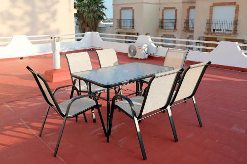 a glass table and chairs on a roof at Chalet Completo Luna de Carboneras in Carboneras