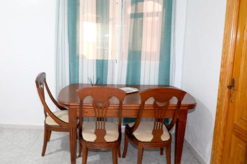 mesa de comedor con 4 sillas y ventana en Chalet Completo Luna de Carboneras, en Carboneras