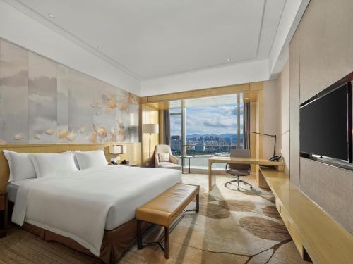 Pokój hotelowy z dużym łóżkiem i telewizorem w obiekcie Crowne Plaza Fuzhou Riverside, an IHG Hotel w mieście Fuzhou