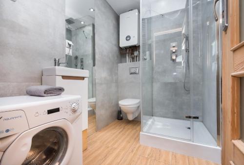 a washing machine in a bathroom with a shower at Apartament Nowy Świat 2 in Gliwice
