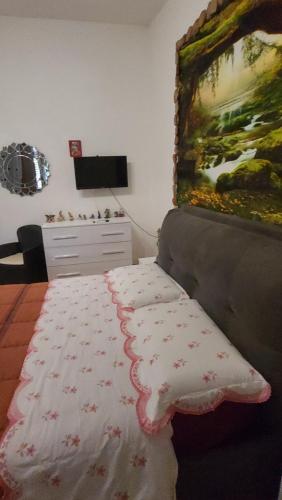 1 dormitorio con 1 cama y una pintura en la pared en Paraiso Sardo 1 en Villasimius