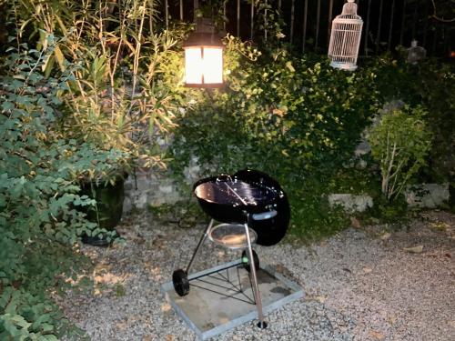 a black grill sitting in a garden with a light at 16 Bis-Gîte-Hôtel-Appartement in Marssac-sur-Tarn