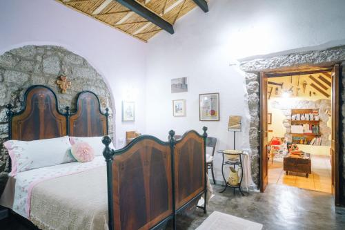 a bedroom with a large bed with a wooden headboard at B&B San Michele in Berchidda