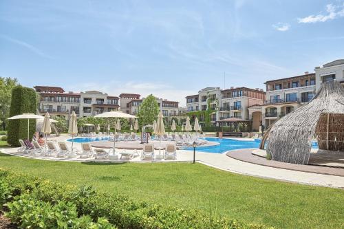 a pool with chairs and umbrellas in a resort at Green Life Sozopol ~ Cozy Studio in Sozopol