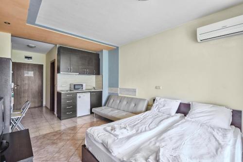 a bedroom with a large bed and a kitchen at Green Life Sozopol ~ Cozy Studio in Sozopol