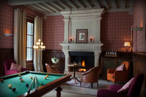 a living room with a pool table and a fireplace at Domaine de la Tortinière in Montbazon