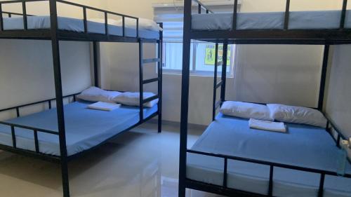 a room with three bunk beds in a dorm at Baie Benie Beach Resort in Balibago