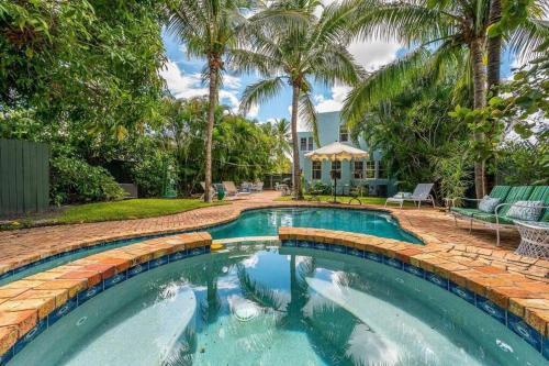 a swimming pool in a yard with palm trees at Welcome to Casa Kanuga, The Secret Gem of WPB! in West Palm Beach