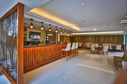 a restaurant with a bar with white chairs and tables at Best Western Plus The Ivywall Hotel - Palawan in Puerto Princesa City