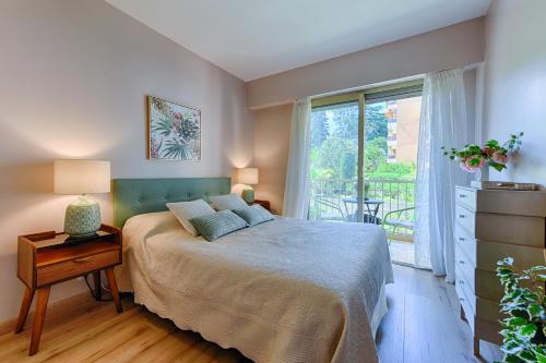 une chambre avec un lit et une grande fenêtre dans l'établissement Happyfew Sainte Anne, à Nice