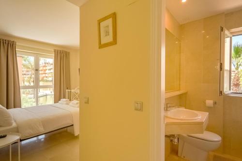 łazienka z łóżkiem, umywalką i toaletą w obiekcie Luxury apartment Sotogrande w mieście San Roque