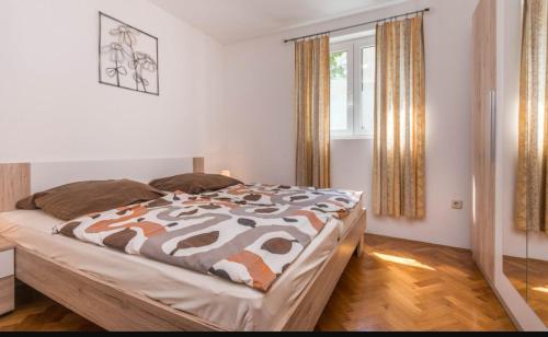 a bedroom with a bed with a brown and white comforter at Apartment Bjanka in Pakoštane