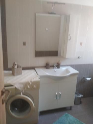 a bathroom with a sink and a toilet and a mirror at Airport Anasta Casa in Artemida