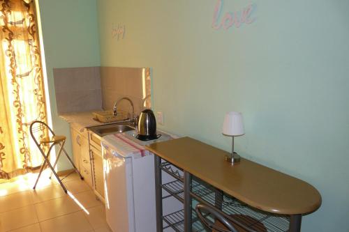 a kitchen with a sink and a table with a lamp at Why Me Eco-friendly Rooms in Tbilisi City