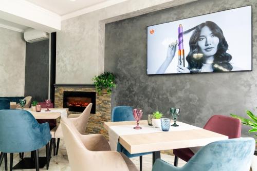 a restaurant with tables and chairs and a tv on the wall at Vega resort Restaurant & Lodge in Orşova