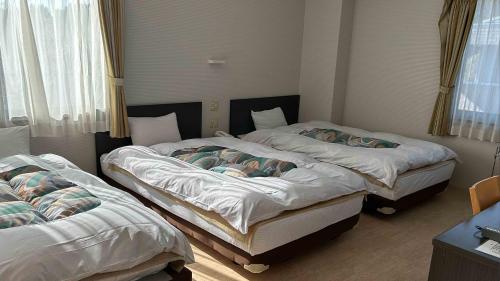 two twin beds in a room with at Ayagawasou in Miyazaki