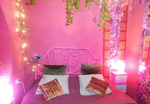 a pink bedroom with a bed in a room with lights at MAISONETTE Fata Bislacca, calcata in Calcata