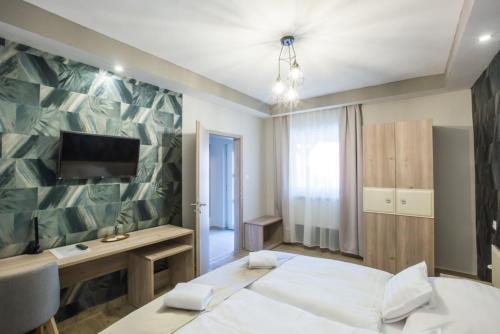 1 dormitorio con 1 cama y TV en la pared en Fogadó a Két Tölgyfához, en Sümeg