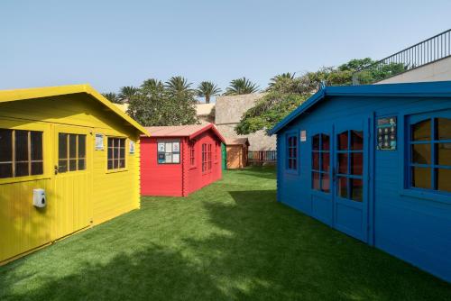 a row of colorful houses on a lawn at Alua Village Fuerteventura - All Inclusive in Playa Jandia