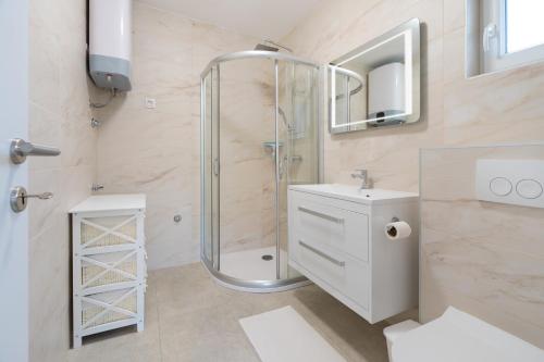 a bathroom with a shower and a toilet and a sink at Number One Apartments in Vir
