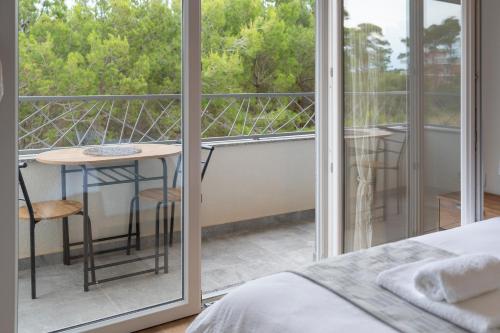 a bedroom with a bed and a balcony with a table at Number One Apartments in Vir
