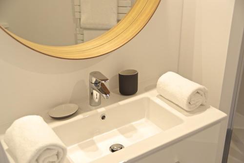 a bathroom with a white sink and a mirror at Chartres - Appartement 1 chambre avec ascenseur in Bordeaux