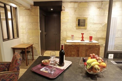 une table avec un bol de fruits et une bouteille de vin dans l'établissement Sauvageau - Appartement 1 chambre avec Parking, à Bordeaux