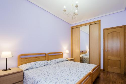 a bedroom with a bed and a chandelier at Apartamento céntrico Candás in Candás