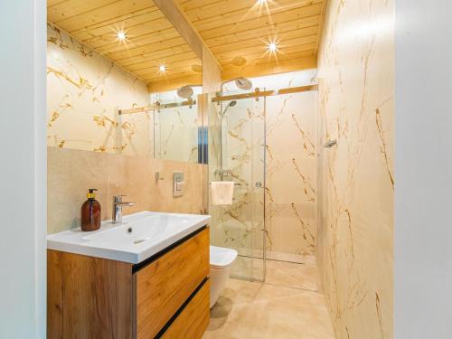 een badkamer met een wastafel en een douche bij Apartamenty Sailor in Pogorzelica