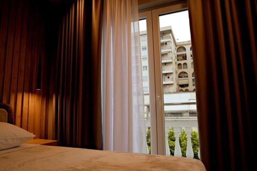 a bedroom with a window with a view of a building at Sol Hotel in Shkodër