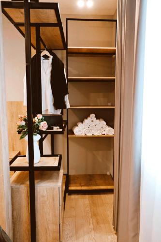 a walk in closet with a suit on a rack at Sol Hotel in Shkodër