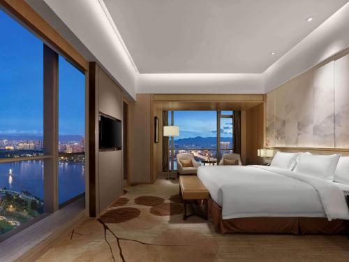 um quarto com uma cama grande e uma janela grande em Crowne Plaza Fuzhou Riverside, an IHG Hotel em Fuzhou