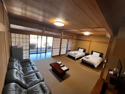 a living room with a couch and a bed at Toyokawa Grand Hotel in Toyokawa