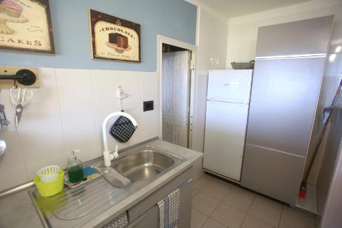 a kitchen with a sink and a refrigerator at Ca' La Stella Sea-view Apartments in Porto Azzurro