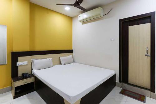 - une chambre avec un lit blanc et un ventilateur dans l'établissement SPOT ON 81399 Hotel Rainbow Regency, à Rourkela