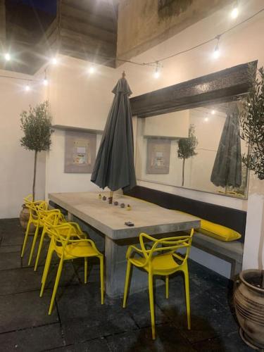 a table with yellow chairs and a large umbrella at Luxury Retro 4 Bed Town House in heart of Alnwick in Alnwick