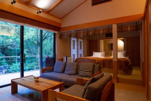a living room with a couch and a bed at Tsukiyominoza in Ise
