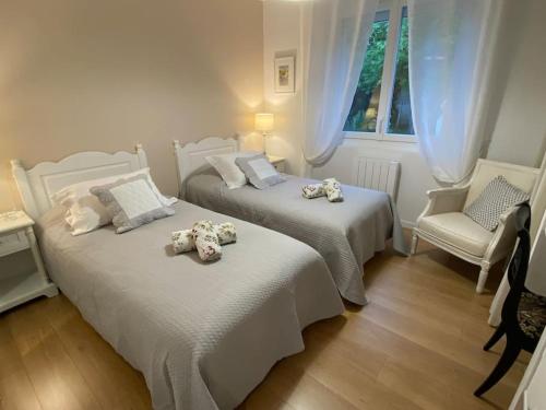 Duas camas com bichos de peluche num quarto em Gite-le-7 em Brive-la-Gaillarde