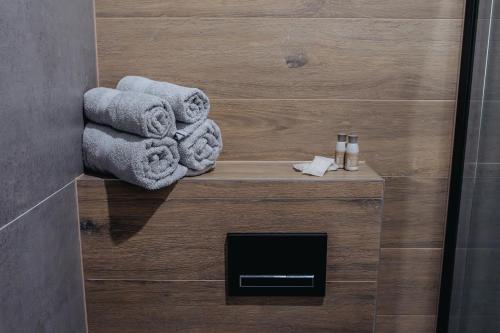 a bathroom with towels on a wooden wall at APARTAMENTY PRUCHNICKA in Jarosław