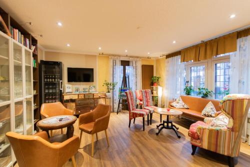 ein Wohnzimmer mit Stühlen, einem Sofa und Tischen in der Unterkunft Hotel Weiler in Oberwesel