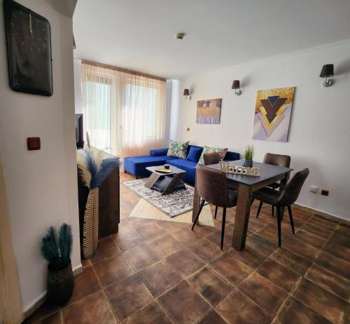 a living room with a table and a blue couch at Синьо лято /Blue summer in Sunny Beach
