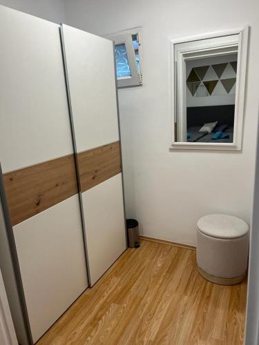 a room with white walls and a stool and a window at Apartman Lara in Zagreb