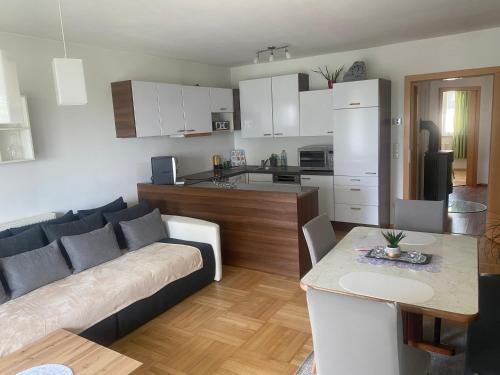 sala de estar y cocina con sofá y mesa en Wohnhaus City Süd en Herzogsdorf