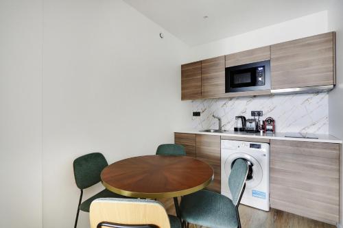 une cuisine avec une table et une machine à laver dans l'établissement Pick A Flat's Apartment in Montorgueil - Rue Notre Dame de Recouvrance, à Paris