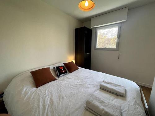 - une chambre avec un lit blanc et une fenêtre dans l'établissement Appartement Hyper Centre, à Concarneau